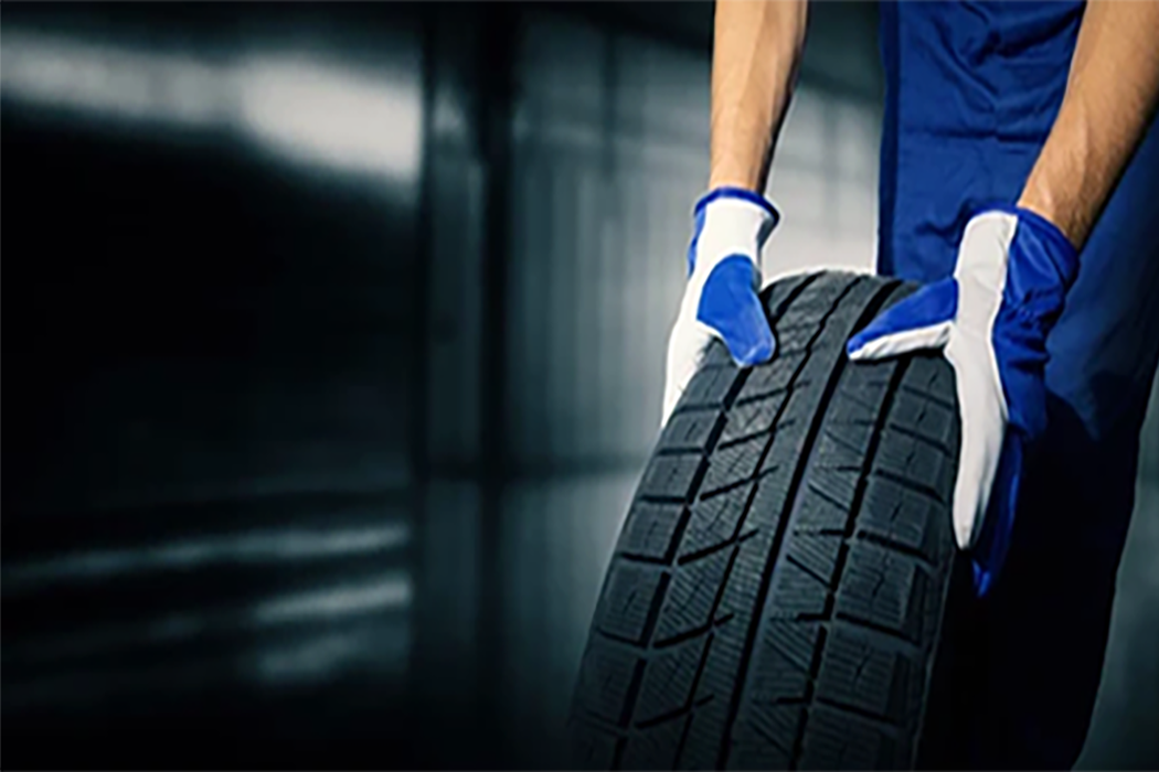 man with gloves on checking the pressure of a tire