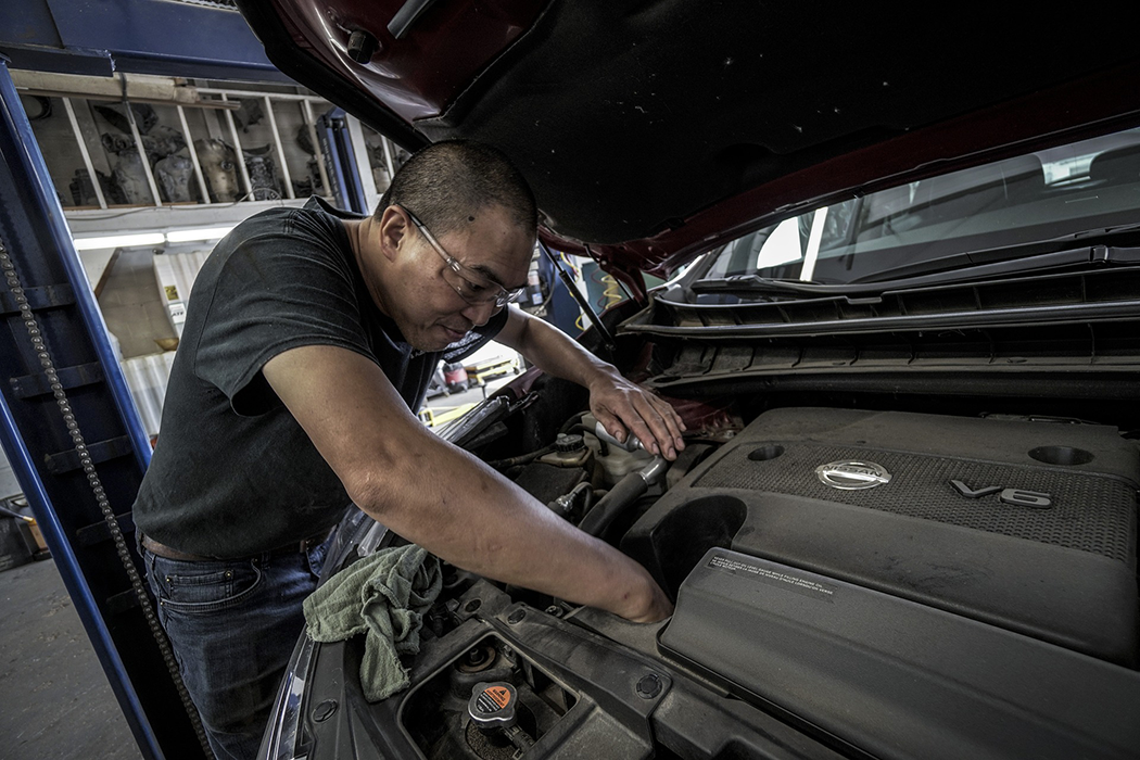 man repairing vehicle motor